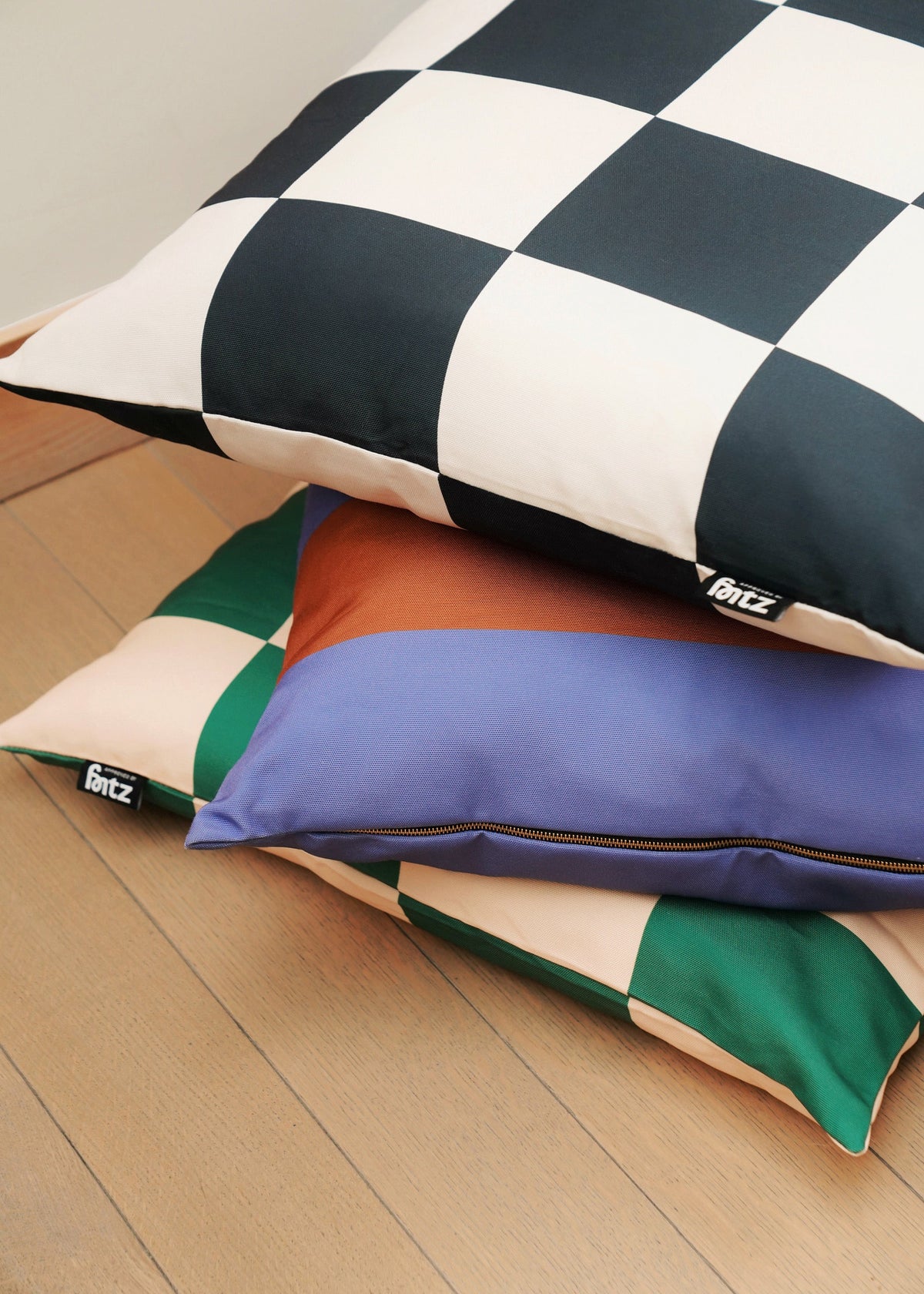 Fritz Bed cushions in checked and striped prints stacked together